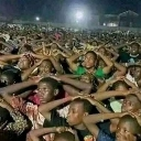 A large crowd of people with their hands on their heads in a gesture of shock.