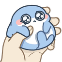 A tiny blue baby shark with large, teary eyes being held and squeezed by a hand.