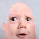 Distorted human face with large wide eyes and an open mouth looking confused.