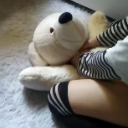 Person aggressively hugging a white plush dog toy.