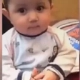A young toddler with a serious, unimpressed facial expression looking directly at the camera.
