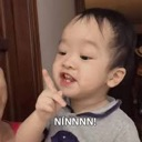 A toddler wagging their index finger while saying no.