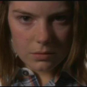 Person with a serious, unimpressed facial expression looking directly into the camera.