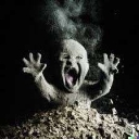 A dusty baby emerging from a pile of dirt with its mouth wide open in a scream.