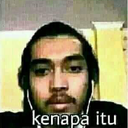 A man with a blank expression stares directly at the camera with the words kenapa itu written at the bottom.
