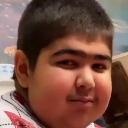 A young boy looking directly at the camera with a highly suspicious and skeptical facial expression.