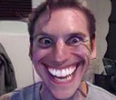 Jerma985 making an exaggerated, wide-eyed, and toothy grin while looking directly at the camera.
