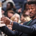 Jimmy Butler squinting intensely while holding and reading a piece of paper.