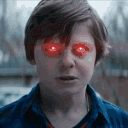 A boy with glowing red laser eyes staring intensely at the viewer.