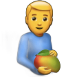 A person with blonde hair wearing a blue shirt gently cradling a large mango against their stomach.