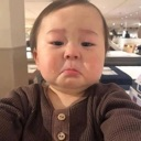 Toddler with a trembling lip and teary eyes looking directly at the camera.