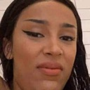 Woman with sharp eyeliner looking at the camera with a skeptical and unimpressed expression.
