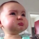 Baby with a teary-eyed expression and a deeply pouting mouth.