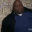Huell Babineaux lying back comfortably on a large pile of cash.