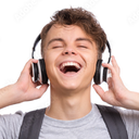 A smiling teenager with eyes closed wearing large headphones and a backpack.