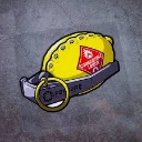 A yellow lemon shaped like a hand grenade with a metal pin and a red warning label.