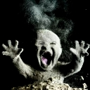 A baby covered in dust with a wide-open mouth screaming while emerging from a dark background.