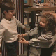 A young boy and girl walking toward each other and sharing a warm, friendly hug.