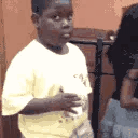 Young boy looking off-camera with a skeptical and confused expression while holding a cup.