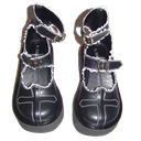 Black platform Mary Jane shoes with white cross detailing and buckled straps.