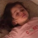 A toddler lying on the floor with an expression of total exhaustion.