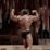 Bodybuilder posing with arms flexed to show off back and arm muscles.