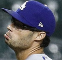 Joe Kelly wearing a blue baseball cap with a look of intense annoyance and pouting lips.