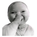 Baby with a mischievous expression covering its nose and mouth with its hand.