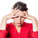 Woman holding her head in her hands with an expression of deep frustration and exhaustion.