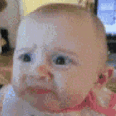 Baby making a skeptical side-eye face with a pursed mouth.