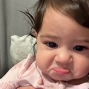 Baby making a skeptical, unimpressed face with pursed lips.