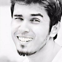 Man with a goatee winking and smiling broadly.