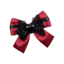 A red satin bow with black lace trim and a small black heart charm in the center.