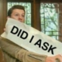 Tom Holland holding a white sign with the text DID I ASK printed in bold black letters.