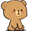 Mocha the brown bear sitting with a serious and slightly pouty expression.