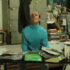 A man wearing a blue turtleneck flips a table in a fit of rage.
