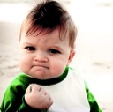 A toddler clenching his fist in a gesture of success and determination.