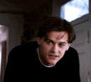 Leonardo DiCaprio looking down and then up with an awkward, self-conscious expression.