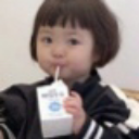 A young girl with a bob haircut drinks from a small milk carton with a neutral, observant expression.