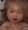 A child with wide, blue eyes and an open mouth looking confused.