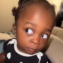 A young child looking to the side with a skeptical and judgmental facial expression.
