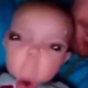 Baby face distorted with a wide-angle lens effect showing a confused expression.