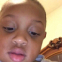 Young child looking into the camera with a confused and skeptical facial expression.