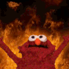 Elmo stands with arms raised in front of a large, bright orange fire.