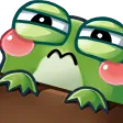A green frog with pink cheeks peeking over a brown ledge with narrowed, suspicious eyes.
