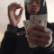 Person holding a fan of cash in front of their face while flexing.