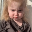 A toddler with a skeptical, unimpressed expression looking directly at the camera.