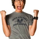 Teenage boy cheering with fists raised in the air and mouth open in excitement.