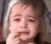Young child crying with a pained expression and hand near their mouth.