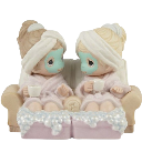 Two figurines wearing robes and face masks sitting together on a couch.